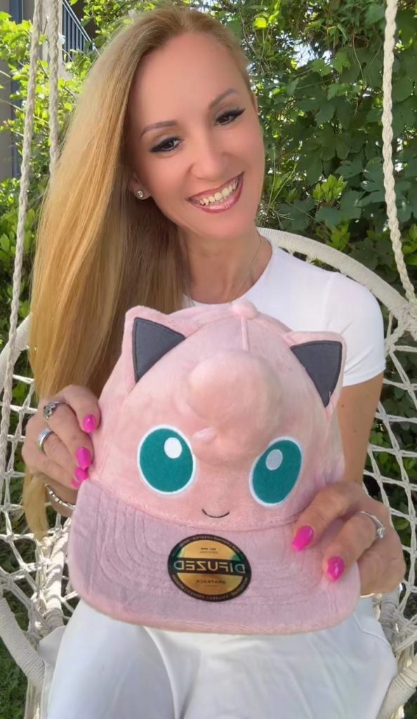 Frau hält rosa Mütze mit Cartoon-Gesicht