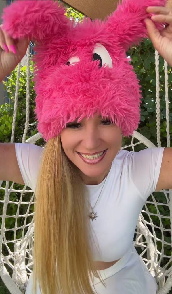 Frau mit pinkem Hasenkostüm auf Schaukel