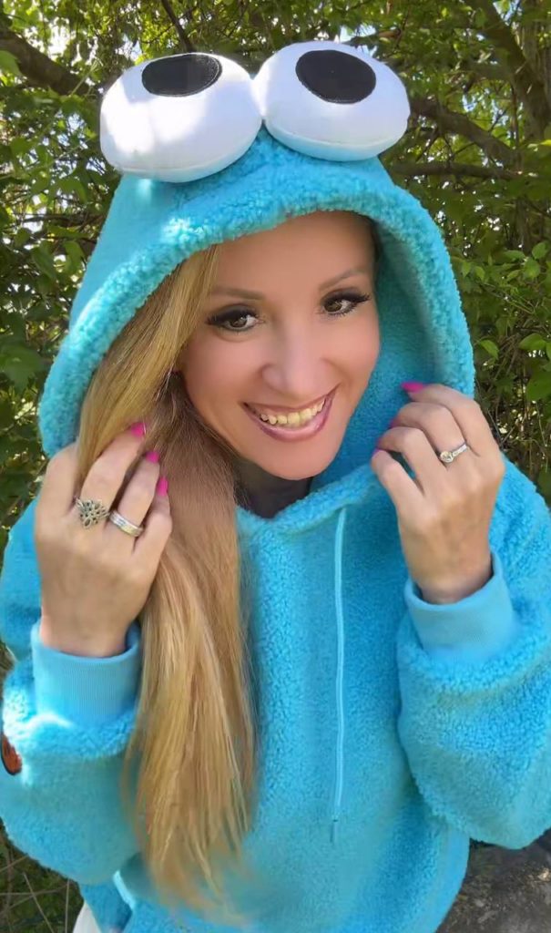 Frau im blauem Hoodie mit großen Augen am Kapuze.