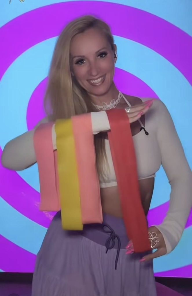 Frau mit bunten Bändern vor farbigem Hintergrund