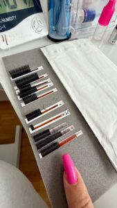 Künstliche Wimpern auf grauer Unterlage angeordnet.